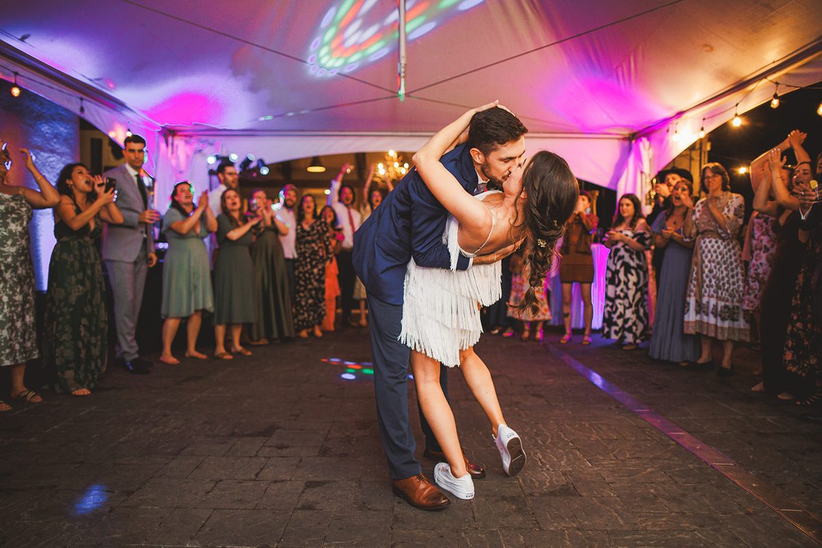 Patrick dipping Andrea, now in a short fringe dress and sneakers, into a kiss on the dance floor as the tent glows pink