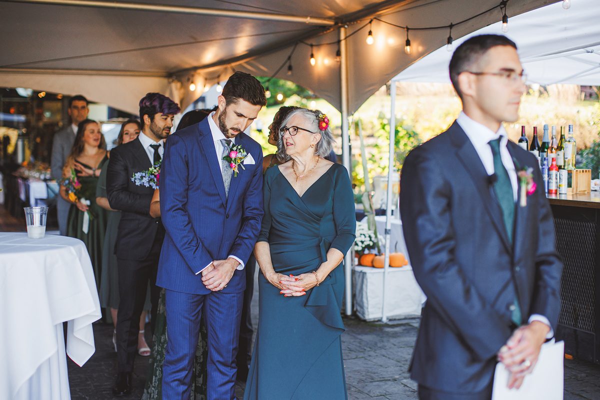 Patrick waiting quietly under the tent beside family before the processional begins