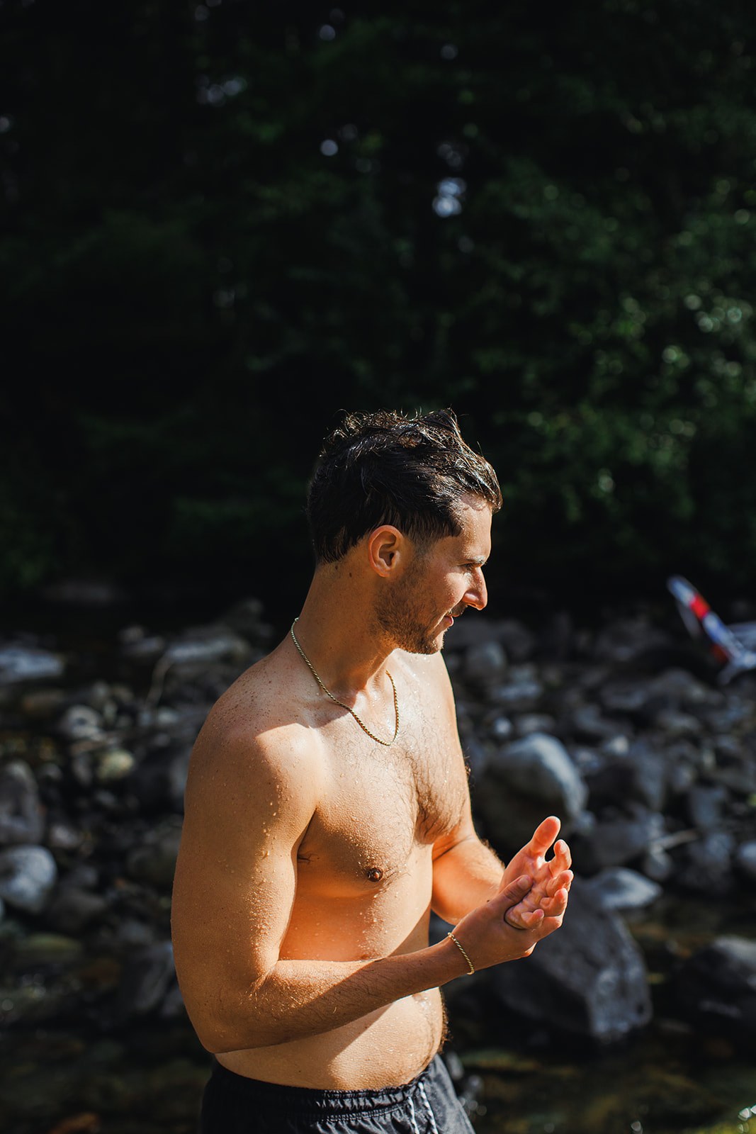 AJ standing in the shallows on the morning of his wedding, wringing the cold water off his hands, the far bank dark green behind him