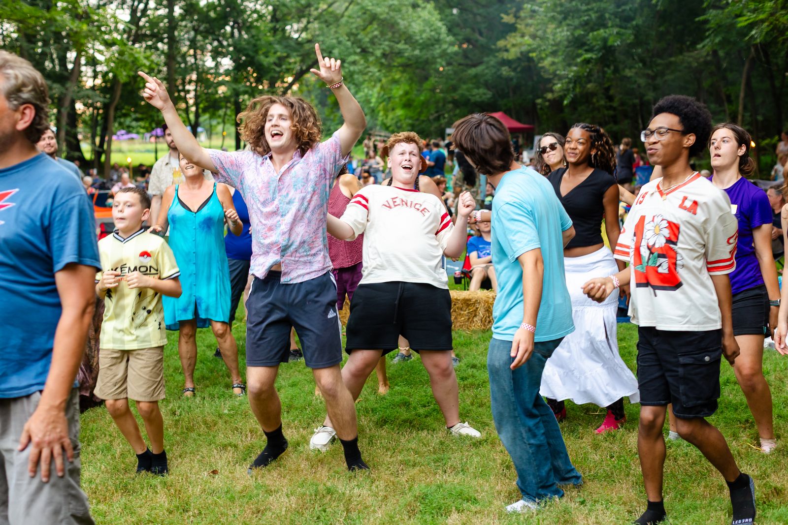 Young dancers erupting in front of the stage at Tomato Jam, one with an arm thrown up mid-shout