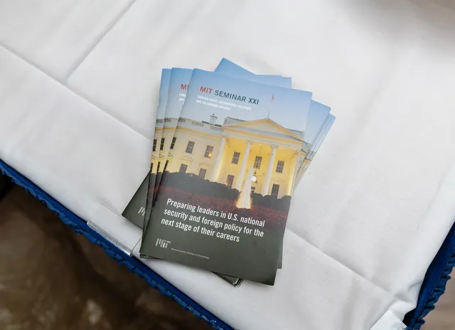 Stack of printed seminar programs on a white tablecloth.