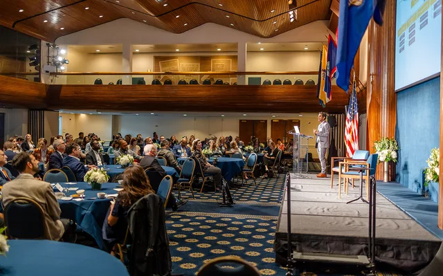 Wide view across full ballroom audience toward stage.