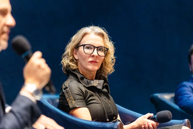 Panelist with glasses and mic.