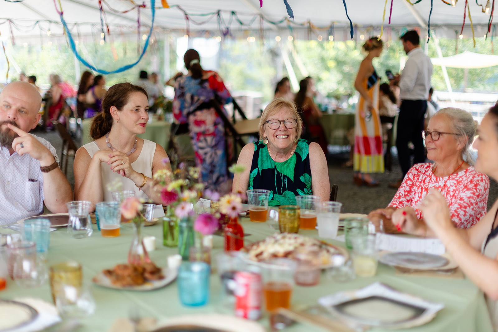A grandmother laughing hard at a ribboned dinner table