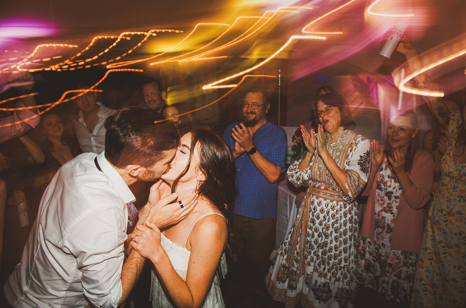 Andrea and Patrick kissing on the dance floor at the Bavarian Inn while their families clap around them